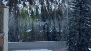 A snowy landscape with a mountain in the background, a building with a stone facade, and a snow-covered ground. - Fantastic 6-bedroom house in Avon perfect for your next getaway. (Avon)