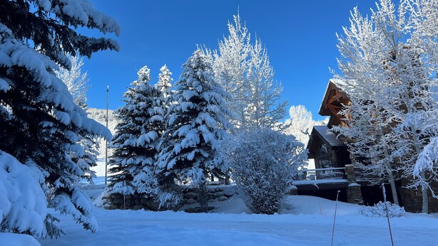 A snow-covered landscape with a wooden cabin and snow-laden trees. - Fantastic 6-bedroom house in Avon perfect for your next getaway. (Avon)