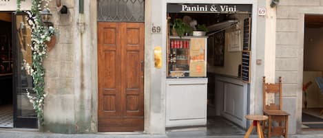 A storefront with a wooden door and a sign for 'Panini & Vini'.