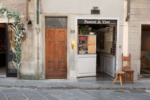 A storefront with a wooden door and a sign for 'Panini & Vini'. - San Niccolò Elegant Apartment (Florence)