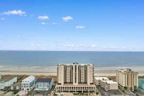 A beachfront hotel with multiple buildings, a parking lot, and a clear view of the ocean. - 3 Bdrm North Shore Villa w/ Lazy River, Hot Tub (North Myrtle Beach)