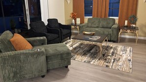 A living room with a sofa, armchairs, a coffee table, and a rug. - This home has been rented annually and not available on VRBO (Cape Coral)