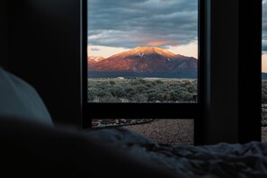 A window view of a mountain landscape with a building in the foreground. - Casa de Luz - Privacy and views beyond belief with hot tub and Sauna (El Prado)