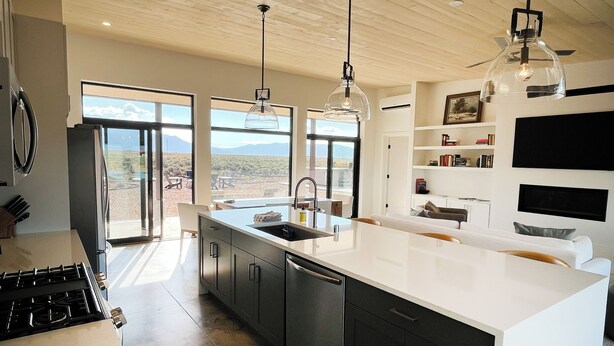 Una cucina moderna con un'isola grande, forno integrato e vista sul paesaggio desertico.