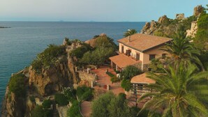 A coastal property with a stone pathway leading to a building with a tiled roof, surrounded by lush greenery and overlooking the sea. - Villa Faraglioni – Private Beach in Cefalù (Cefalù)