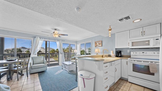 A spacious kitchen with a large island, white cabinetry, and a view of the outdoors. -   🐬GS Plantation Resort Conference Center 1254 | Resort Amenities+Walk to Beach (Gulf Shores)