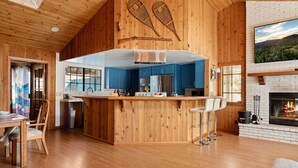 Un'ampia cucina con isola centrale, mobili blu e un camino.