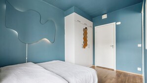 Een slaapkamer met een bed, een kast en een deur.