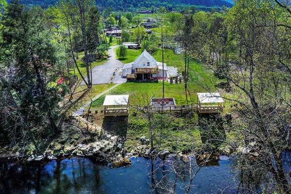 A lakeside lodge with a central building, guest cabins, and a dock. - Riverfront Barndominium, Incredible Outdoor Space! (Townsend)