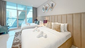 Et moderne hotelværelse med en stor seng, udsigt over byen og en dekorativ vægkunst.