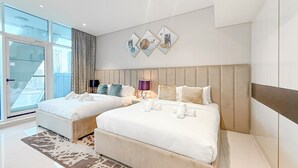 Et moderne hotelværelse med to senge, et stort vindue og udsigt over byen.