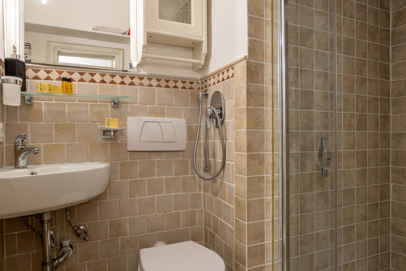 Een badkamer met een wastafel, toilet en douche.