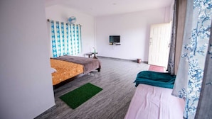 Un dormitorio con cama, televisión, ventilador y puerta.