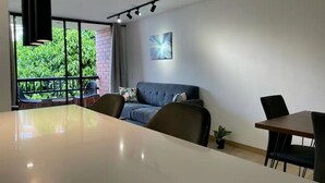 Una habitación moderna con una mesa grande, un sofá y una zona de comedor.