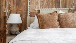 A bed with white bedding and two brown pillows, a wooden headboard, and a bedside table with a lamp and a clock. - Chandler Southwest Gem w/Private Backyard Retreat! (Chandler)