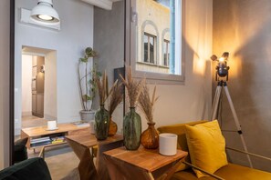 A modern living room with a wooden coffee table, a yellow sofa, and a tripod-mounted lamp. - CHIESA 12 3P - Florence (Firenze)