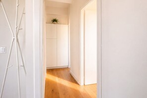 Un couloir avec un plancher en bois et des murs blancs.