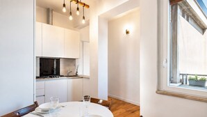 A modern kitchen with white cabinets, a round dining table, and a window with a view. - GuestHost - Cozy and modern 70 sqm apartment, able to comfortably accommodate up to 6 people, located on the 5th floor of a modern building with lift (NOT suitable for disabled people). The property is located in an extremely strategic area, just 400 met (Florence)