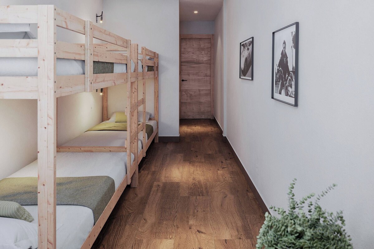 Un dormitorio con literas, un pasillo y cuadros en la pared.