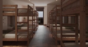 Une pièce avec des lits superposés alignés, un plancher en bois et une porte donnant sur une autre pièce.