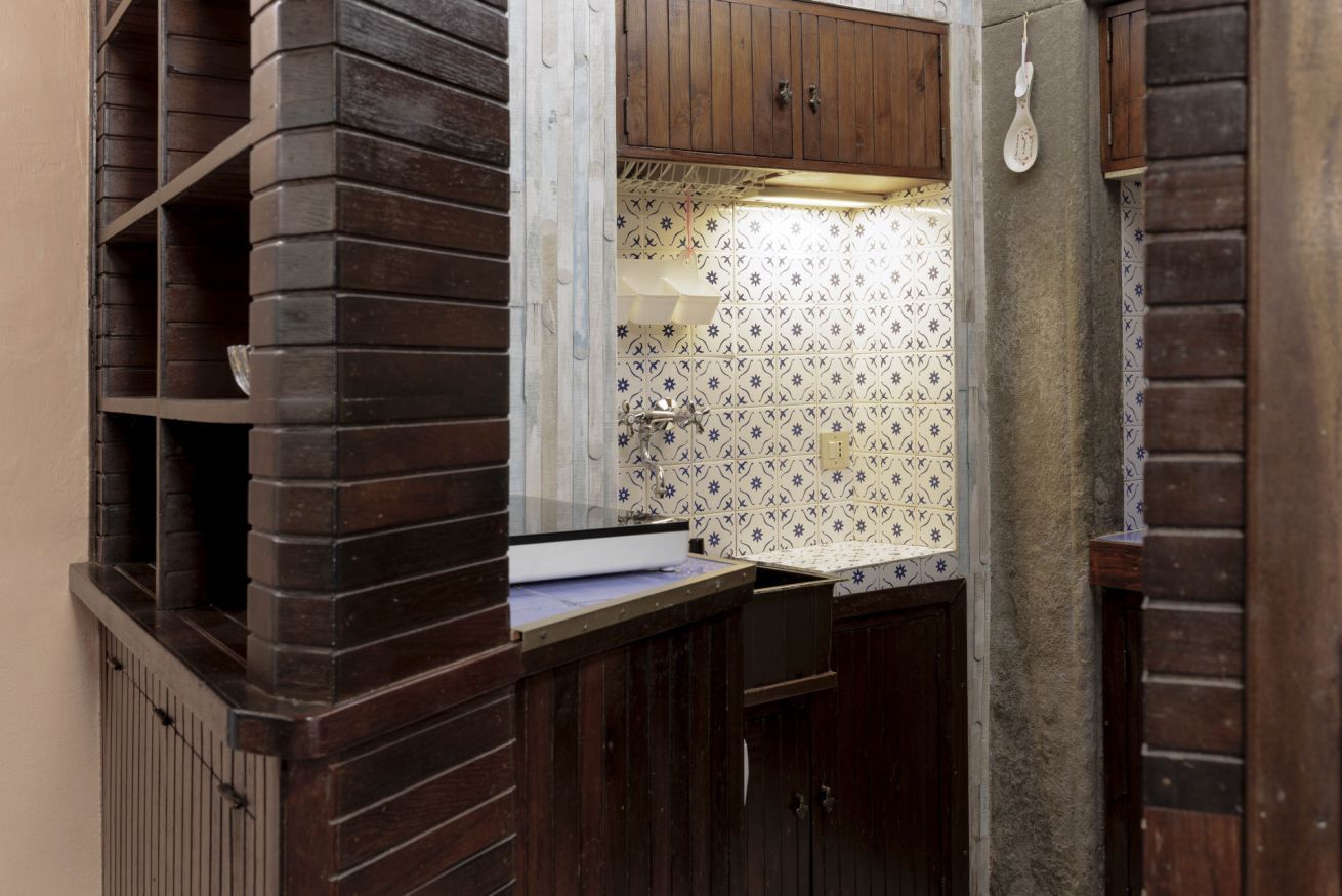 A bathroom with a wooden vanity, a sink, and a patterned backsplash.