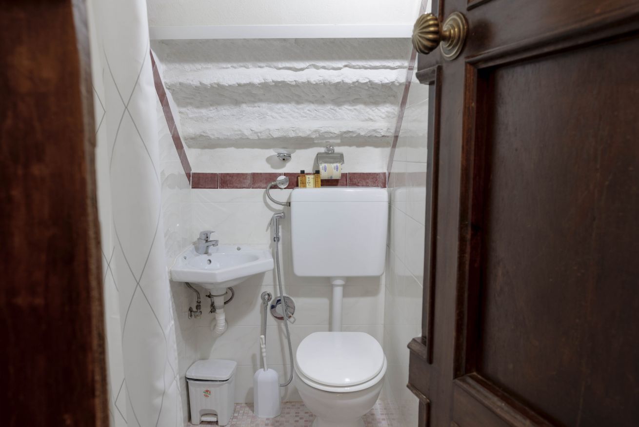 A small bathroom with a toilet, sink, and shower.