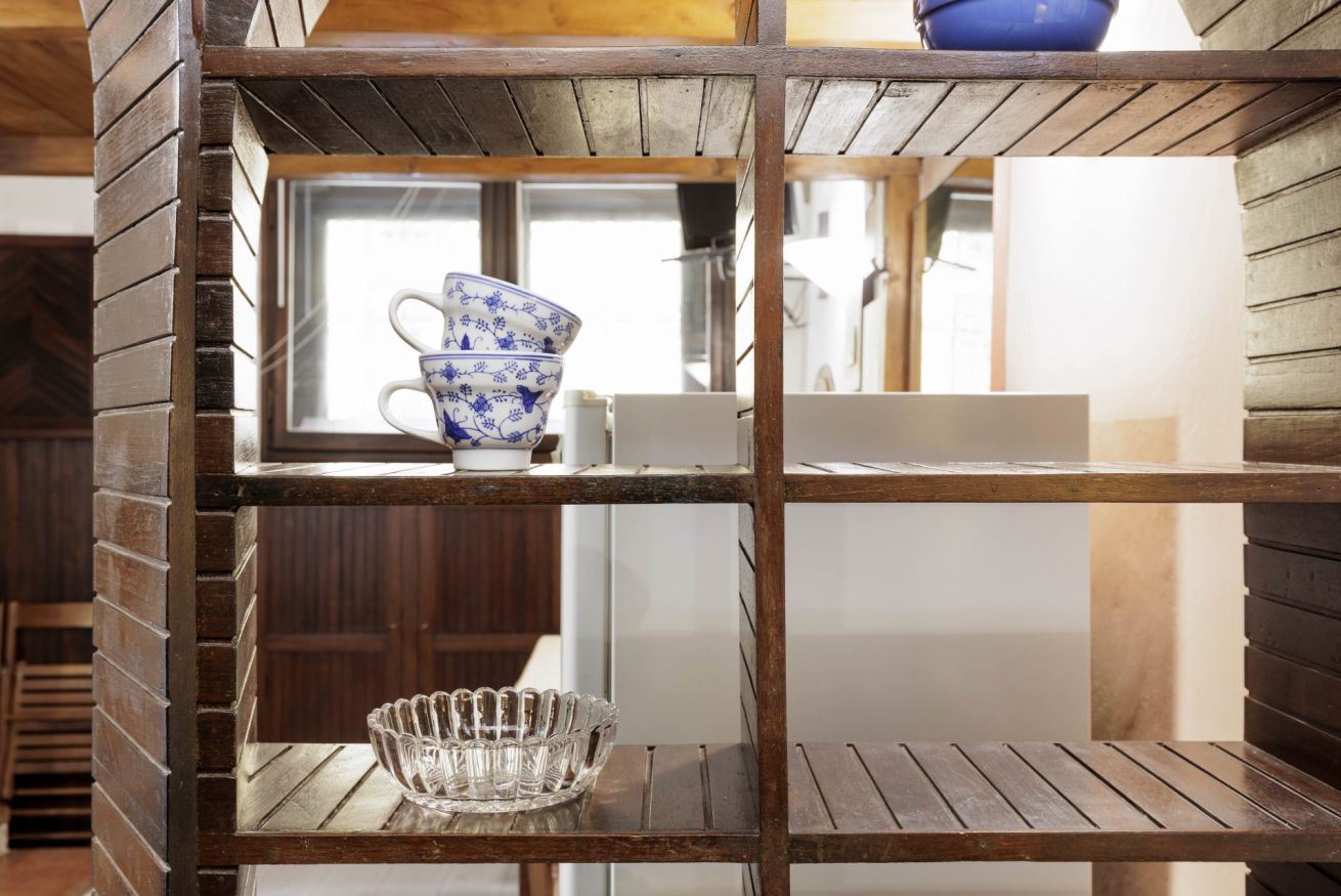 A wooden shelf with a blue and white bowl and a clear glass bowl.