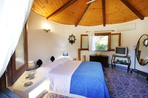 Ein Schlafzimmer mit Bett, Nachttischen, Fernseher und Spiegel.