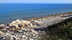 A rocky shoreline with clear blue water and a distant horizon. - Boutique Villa is an exclusive-use property located along the Tyrrhenian coast, nestled in a pine forest overlooking the sea.The main part of the villa consists of three charming cottages. Inside, you’ll find two bedrooms (one double and one twin), a b (Marina di Caronia)