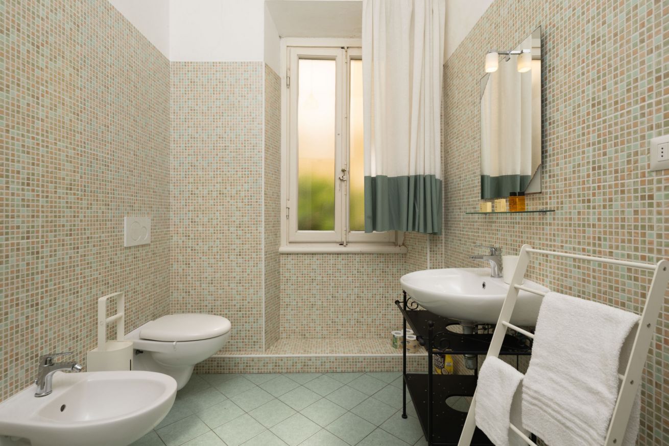 Un baño con dos lavamanos, inodoro y ducha.