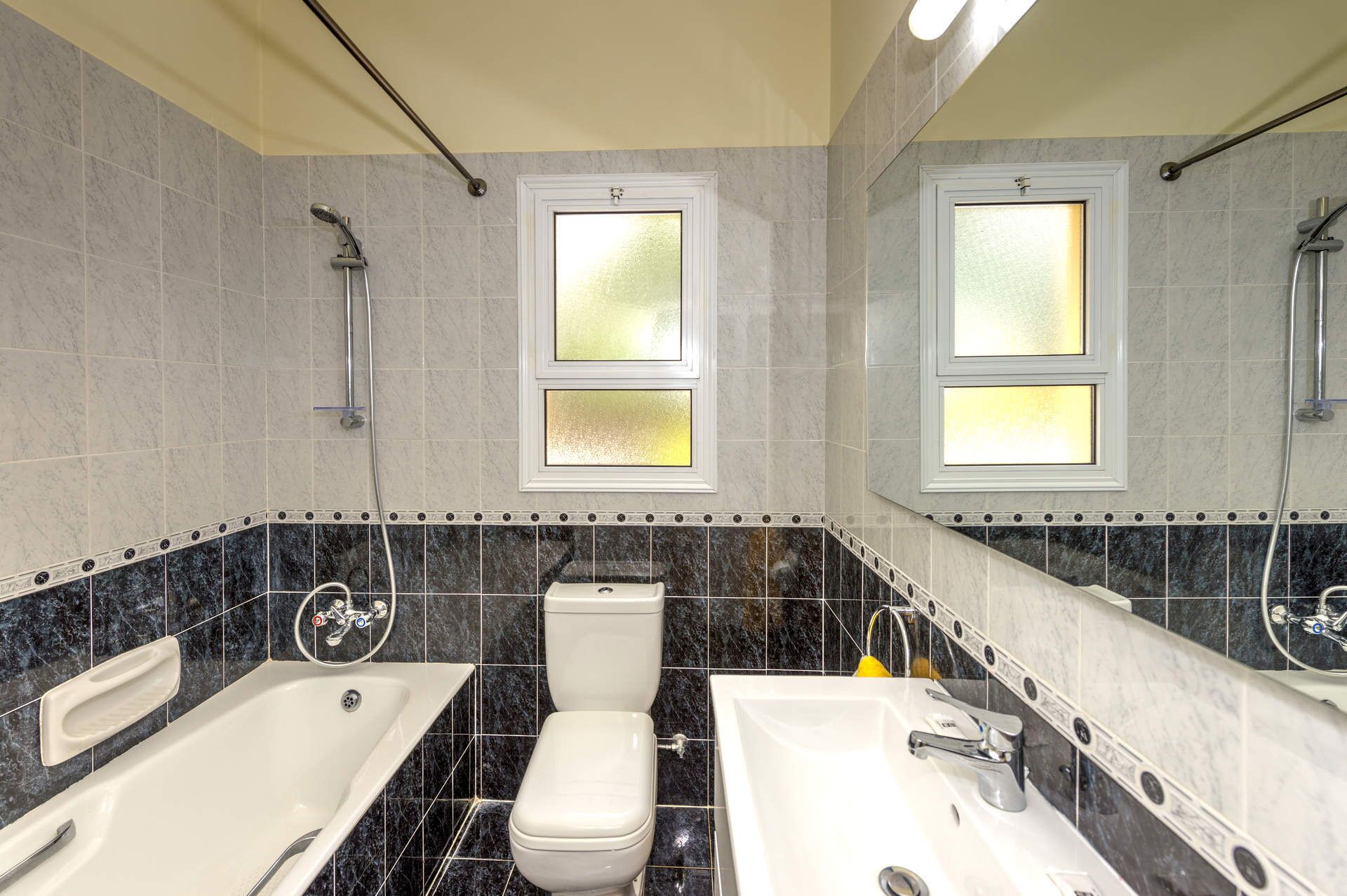A bathroom with two sinks, a toilet, and a shower.