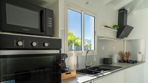 Een moderne keuken met een Bosch oven, een wasmachine, een koffieapparaat en een spoelbak.
