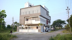 A modern multi-story residential building with a flat roof, large windows, and a balcony. - The Residence 267 Homestay (Mysore)