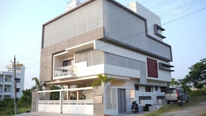 A modern two-story building with a flat roof, large windows, and a balcony. - The Residence 267 Homestay (Mysore)