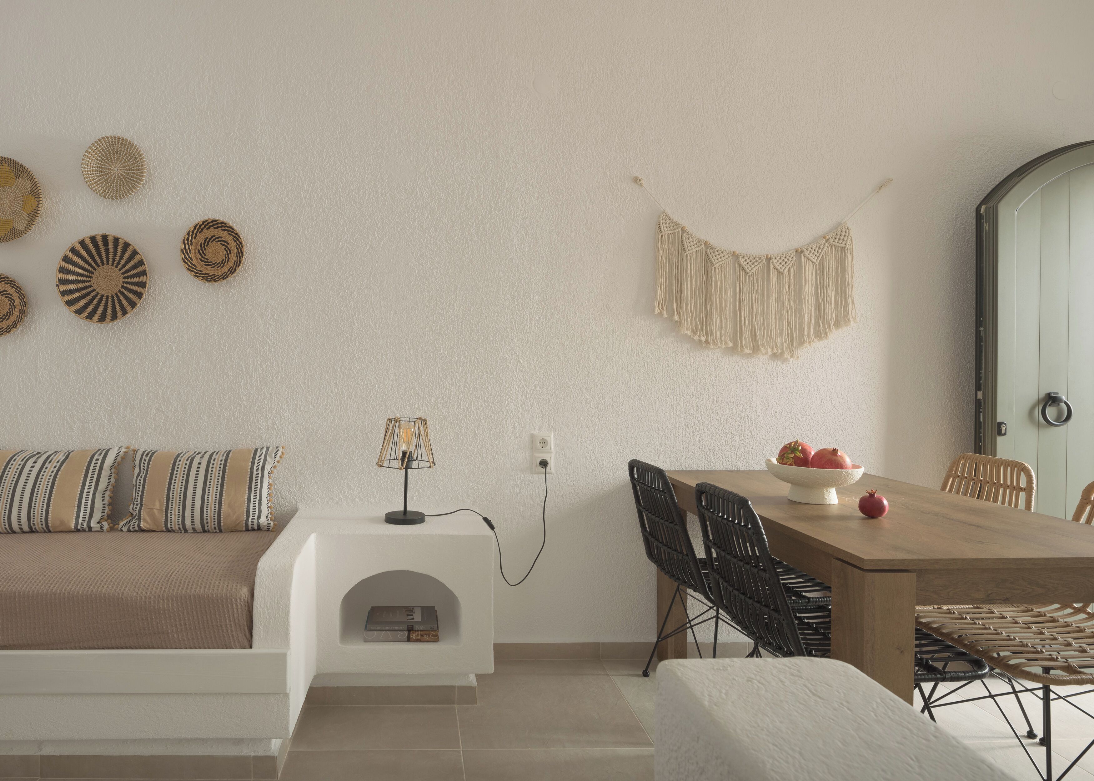 Una sala moderna con un sofá, una mesa de comedor con sillas y decoración en la pared.