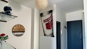 A hallway with a clock, a wall-mounted light fixture, and a door. - Apartment with terrace Etna and sea view near central station (Catania)