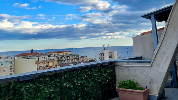 A rooftop terrace with a view of the sea, a green wall, and a potted plant. - Apartment with terrace Etna and sea view near central station (Catania)