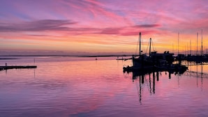 A marina with boats docked, calm water, and a sunset sky. - CASA JO – a beautifully renovated, comfortable fisherman's cottage in the historic center of Olhão (Olhão)