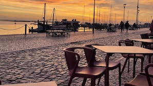 A waterfront restaurant with outdoor seating, a dock, and moored boats. - CASA JO – a beautifully renovated, comfortable fisherman's cottage in the historic center of Olhão (Olhão)