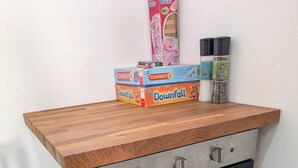 A kitchen with a built-in oven, a wooden countertop, and a box of cookware on top. - Quiet self contained apartment with free parking, close to Hospital (Torquay)