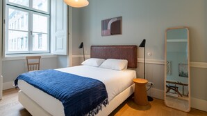 A bedroom with a bed, a window, a mirror, and a lamp. - FLH Heart of Rossio Apartment III (Lisboa ciudad)