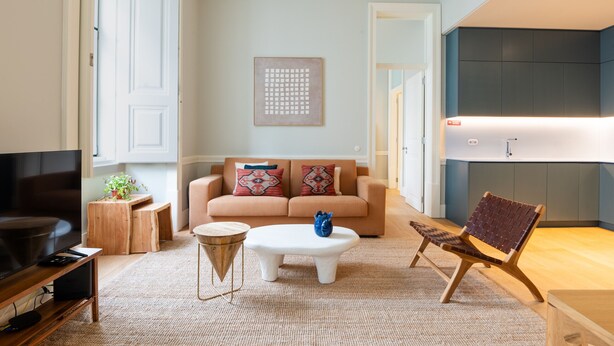 A modern living room with a sofa, coffee table, TV, and a chair. - FLH Heart of Rossio Apartment III (Lisboa ciudad)