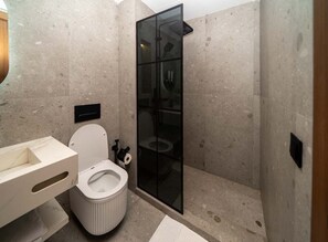 A modern bathroom with a toilet, a glass-enclosed shower, and a marble-tiled floor. - Central Casablanca – Spacious 2‑Bedroom with Terraces (Casablanca)