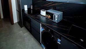 Eine moderne Küche mit integriertem Waschmaschine, einer Mikrowelle und einem Toaster.