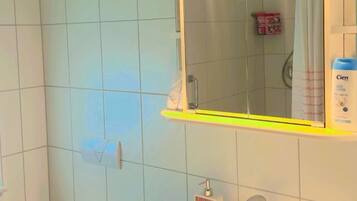 Une salle de bain avec des toilettes, un lavabo et un miroir.