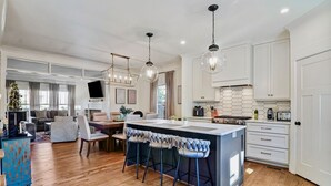 A modern kitchen with a central island, bar stools, and pendant lighting. - Stylish 4BR near Avondale Restaurants | Sleeps 10 (Birmingham)