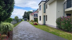 Eine Wohnstraße mit modernen Häusern, befestigter Auffahrt und gepflegten Gärten.