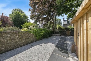 A stone wall, gravel path, wooden fence, and a building with a chimney. - Crown Street Suite 2 - Grampian Lettings (Aberdeen)