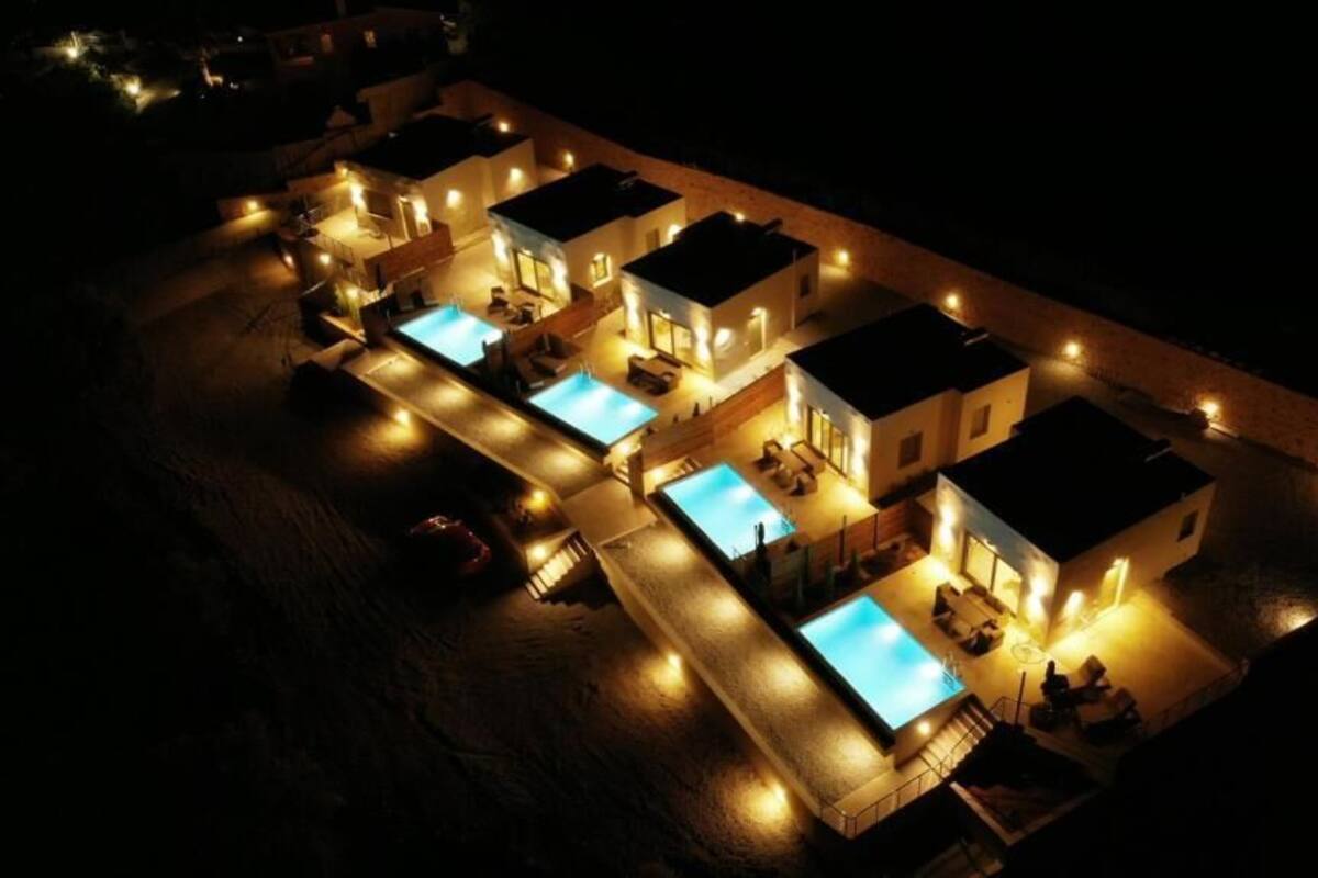 A resort with multiple swimming pools, connected by walkways, and surrounded by well-lit buildings.