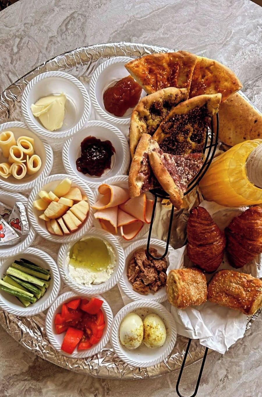 Una bandeja con una variedad de alimentos, incluyendo quesos, carnes y pasteles.